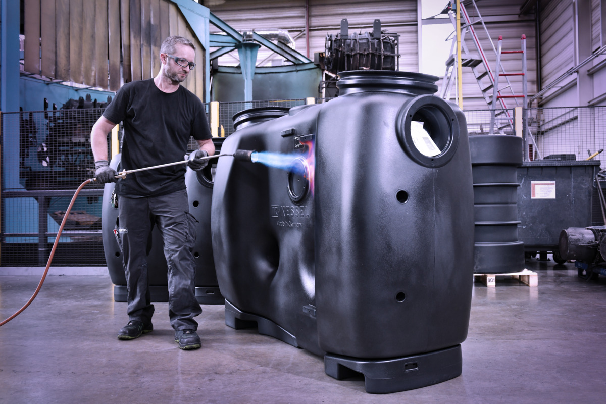 Anlagenbau, Mitarbeiter flämmt Fettabscheider